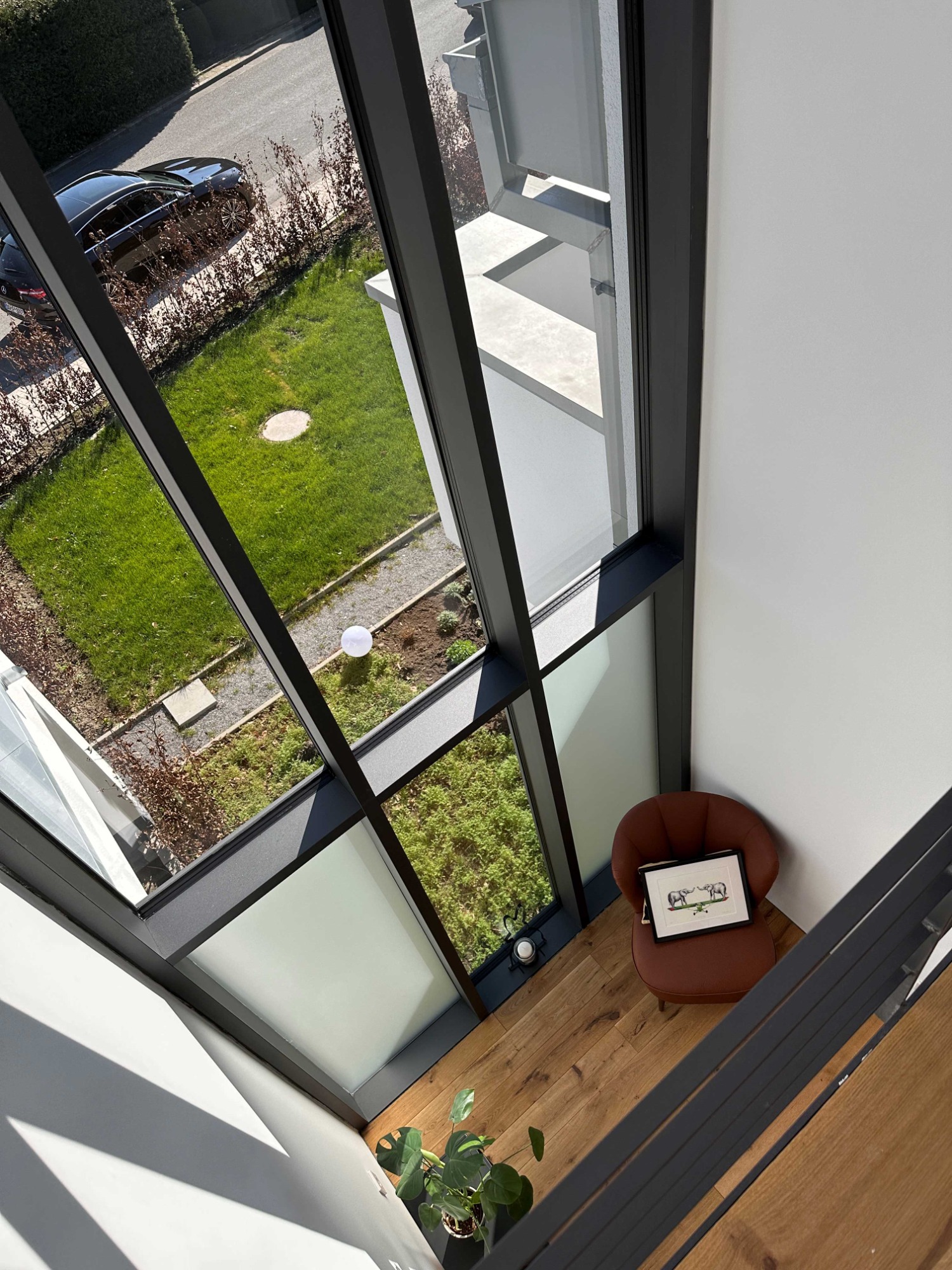 Blick von oben auf einen modernen Raum mit Holzfußboden und einer gemütlichen Sitzgelegenheit.