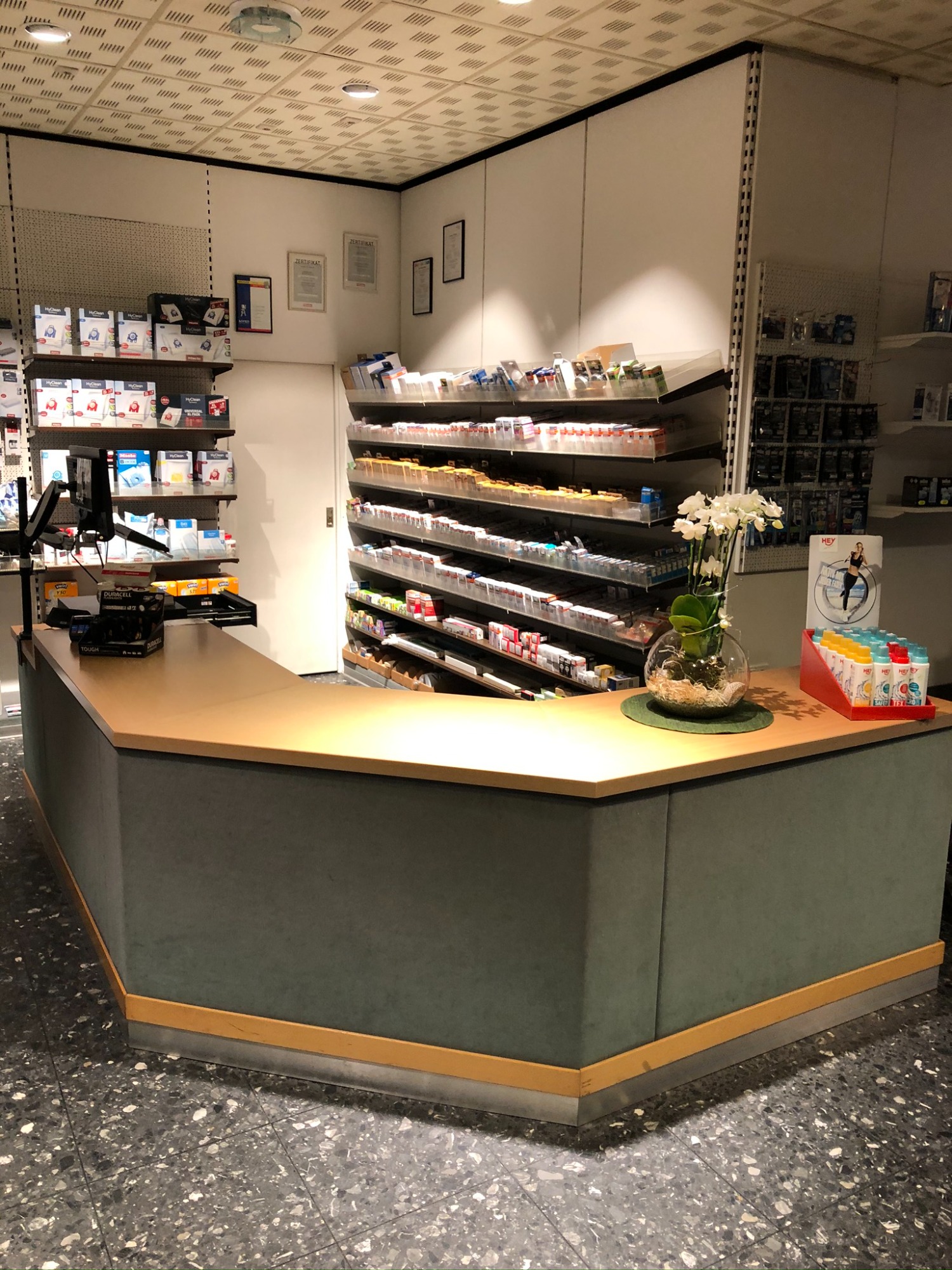 The Empfangstresen mit bunten Zeitschriften und einer Orchidee in einem modernen Raum.